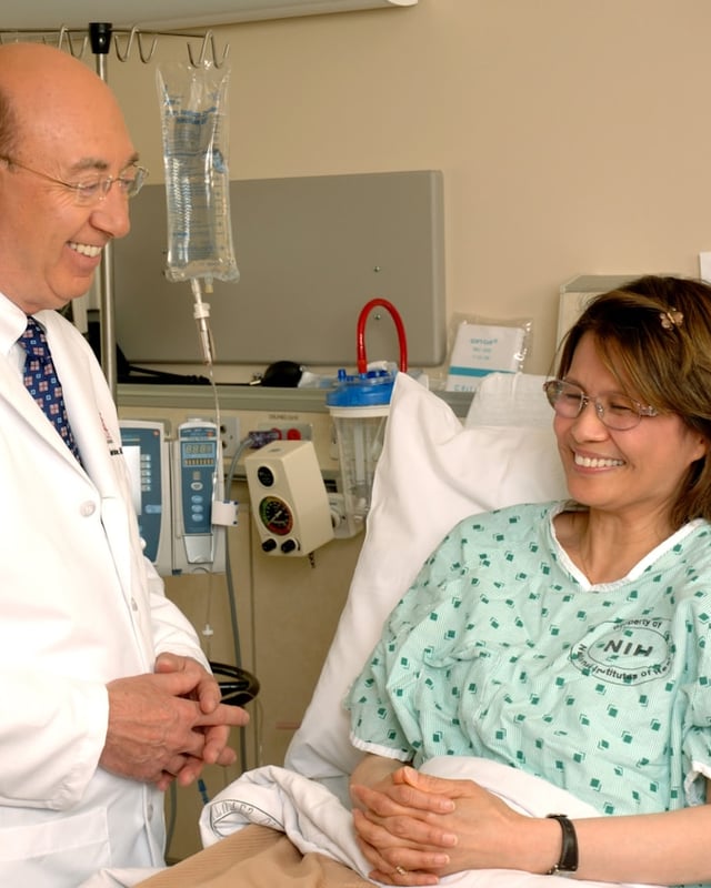 Doctor speaking with a patient at their hospital bedside